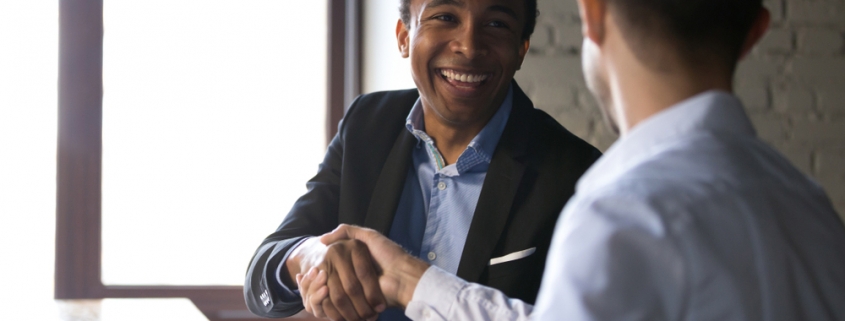 Two businessmen, one black and one white, shaking hands